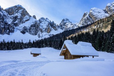 Tarvisio. Snowy houses in Riofreddo valley at  winter at the foot of the Julian Alps clipart