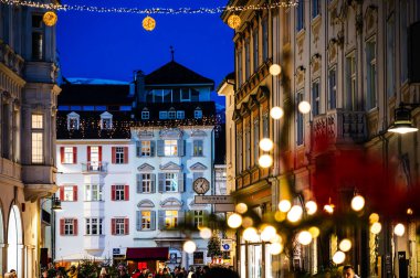 Bolzano, gece ile gündüz arasında. Tarihi binalar arasında Noel atmosferi. Uyarı.