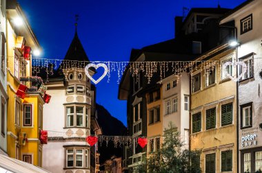 Bolzano, gece ile gündüz arasında. Tarihi binalar arasında Noel atmosferi. Uyarı.