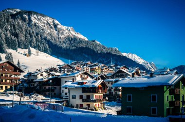 Sappada 'da şafak vakti köyün gündüz manzarası. Dolomitlerin sahne görünümü.