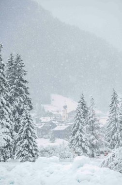 Scenic winter day view of Canazei, the jewel of the Val di Fassa under a heavy snowfall, Italy  clipart