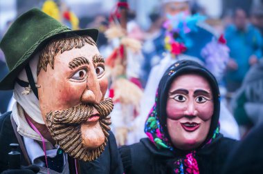 Ancient carnival celebration with people in wooden masks from Sauris. Magic of Carnia for the arrival of spring clipart