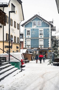 San Candido 'da Noel pazarında yürüyen turistler. Sihirli Val Pusteria Kar Altında.