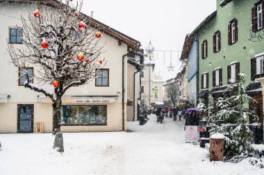 San Candido 'da Noel pazarında yürüyen turistler. Sihirli Val Pusteria Kar Altında.