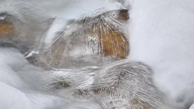 Kış dağlarında akan suyla donmuş akarsu 