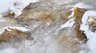 Kış dağlarında akan suyla donmuş akarsu 