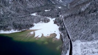Kışın Lago del Predil 'in insansız hava aracından manzara, İtalya' da dağlarla çevrili göl. 