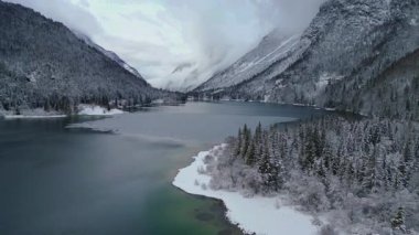 İtalya 'da dağlarla çevrili Lago del Predil Gölü' nün kış manzarası. 