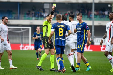 Maçın hakemi Maurizio Mariani, İtalya 'nın Verona kentindeki Marcantonio Bentegodi Stadyumu' nda 17 Mart 2024 'te oynanan İtalyan Serie A karşılaşmasında Hellas Verona FC Milan' a karşı oynadığı gol sonrasında Milano 'dan Theo Hernandez' e sarı kart gösteriyor. - 