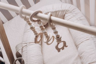 Kozasında oyuncaklar olan ahşap yay, çocuk yuvalarında yeni doğan bebekler için yuva. Çocukluk, çevre dostu güvenli eşyalar ve çocuklar için oyuncaklar. Yeni hayat, bebek egzersizleri, çocuk, çocuk konsepti. Boşluğu kopyala.