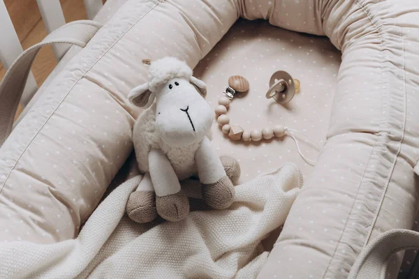 米黄色蚕茧上有柔软的羊玩具 育婴室里有新生儿窝 童年的概念 为儿童提供环保的安全物品和玩具 轻生孩子的房间在里面 该睡觉了 — 图库照片