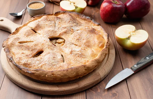 Autumn food. Homemade apple pie with fresh red apples on wooden table