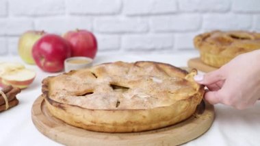 Woman in apron serving apple pie on the table