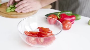 closeup man hands making salad adding vegetables to the bowl , healthy food