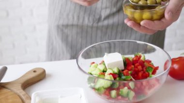 closeup man hands making salad adding vegetables to the bowl , healthy food
