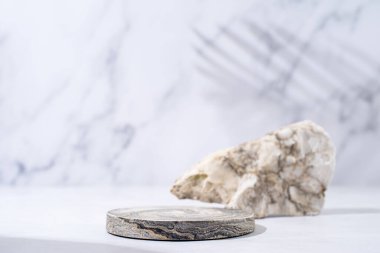 A minimalistic scene of a podium with stones on white background. Round white catwalk for the presentation of products and cosmetics. Showcase with a stage for products, mockup design, seasonal