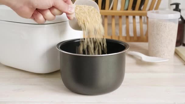 手将糙米从量杯中取出 倒入厨房木制柜台上的饭碗中 健康食品和饮食 — 图库视频影像