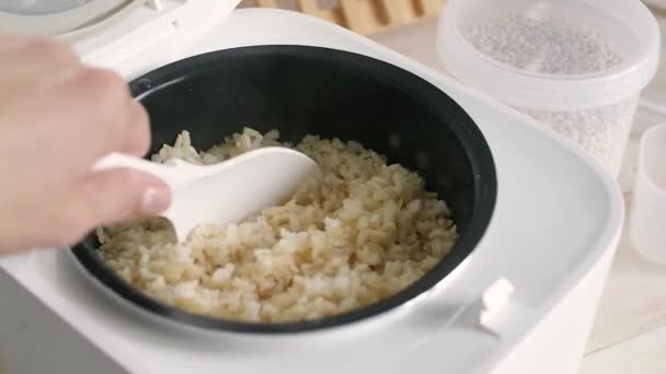 在饭锅里用塑料勺子搅拌糙米 新鲜煮熟的米 健康食品和饮食 — 图库视频影像