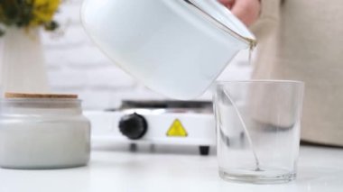 Bahar. Mum yapımı için yaratıcı bir uğraş. Kavanoza eritilmiş soya mumu koymak.