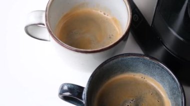 Erkek elleri portafilter tutuyor ve modern kahve makinesi kullanarak evde taze aromatik kahve yapıyor.