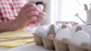 Paskalya yumurtası boyayan adam, merhaba bahar konsepti, Paskalya hazırlığı konsepti. Erkek eller Paskalya Bayramı için yumurta boyuyor.