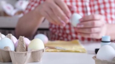 Paskalya yumurtası boyayan adam, merhaba bahar konsepti, Paskalya hazırlığı konsepti. Erkek eller Paskalya Bayramı için yumurta boyuyor.
