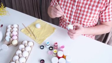 Paskalya yumurtası boyayan adam, merhaba bahar konsepti, Paskalya hazırlığı konsepti. Erkek eller Paskalya Bayramı için yumurta boyuyor.