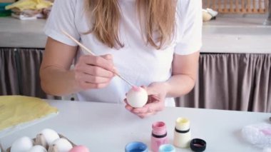 Bayram için paskalya yumurtalarını pastel renklerle boyayan bir kadın. Merhaba bahar konsepti, Paskalya hazırlama konsepti.