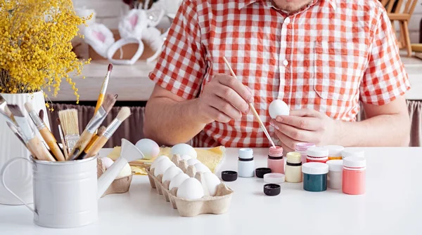 Весенние Праздники Пасха Человек Простой Рубашке Рисует Пасхальные Яйца Домашней — стоковое фото