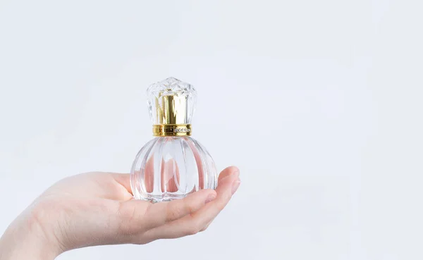 白い背景に女性の手に香水と美しいガラス瓶が隔離され — ストック写真