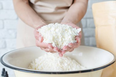 Evde yaratıcı bir hobi. Masada dekoratif aroma mumları yapan kadın soya mumunu ellerle karıştırıyor.