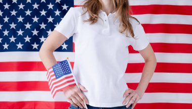 Beyaz polo tişörtlü kadın, Amerikan bayrağı arkaplan, model tasarım. Stüdyo içi çekim