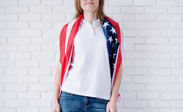 White polo shirt on woman over USA flag background, mockup design. Indoor studio shot
