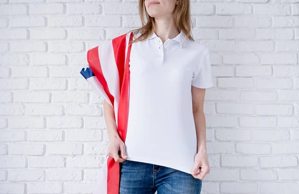 アメリカの国旗を背景にした女性用の白いポロシャツ モックアップデザイン 室内撮影 — ストック写真