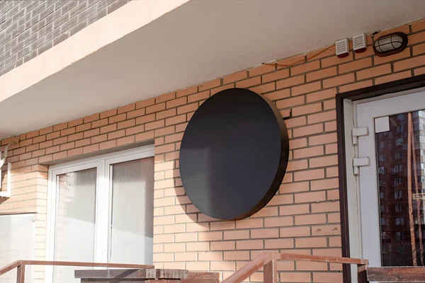 砖墙上的黑色圆形标志 用于造型设计的建筑物外部 — 图库照片