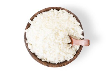 Hindistan cevizi kasesindeki mumlar için organik beyaz soya gevreği beyaz arka planda gölgeli ve düz manzaralı.