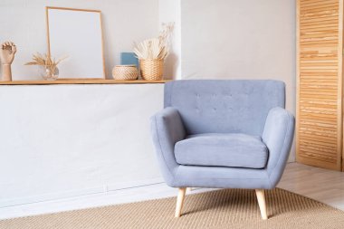 Oturma odasında zarif iç tasarımı olan boho tarzı mavi koltuklar. Hasır dekor, bej renkler