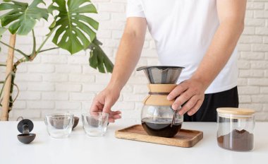 Adam ev mutfağında kahve hazırlıyor.