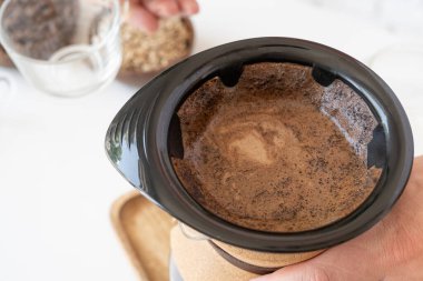 Adam ev mutfağında kahve hazırlıyor.