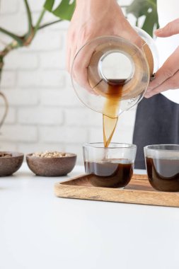 Adam ev mutfağında kahve hazırlıyor.