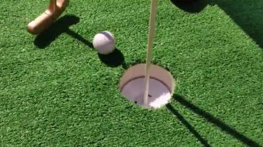 Yaz hobileri. Tanınmayan kişi mini golf oynuyor.