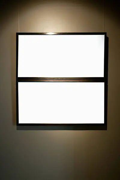 在棕色的墙上挂着空白的相框 画廊里点着发光的灯 模仿着 — 图库照片
