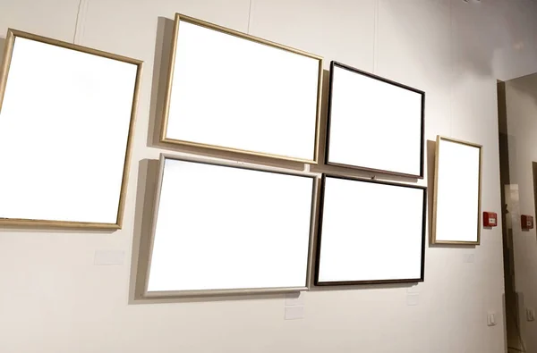 Blanco Fotolijsten Grijze Muur Met Gloeiende Lamp Galerij Model — Stockfoto
