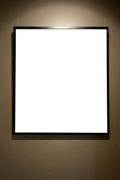 ギャラリーの輝くランプが付いている茶色の壁のブランクの映像フレーム モックアップ — ストック写真