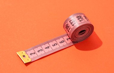 Diyet konsepti. Renkli ölçüm bantları parlak kırmızı arkaplanda üst görünüm, düz yatış, desen