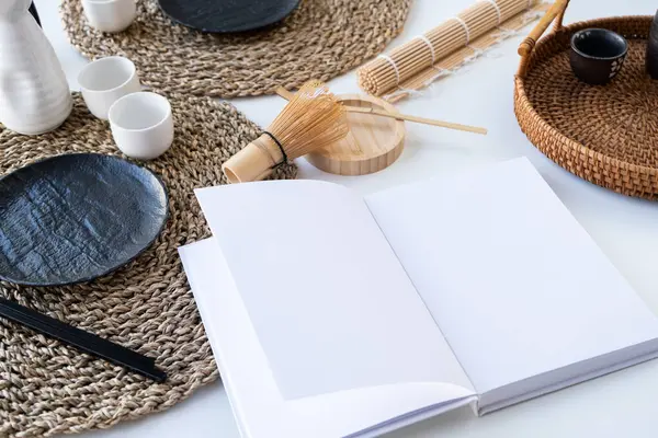 Book mockup design. Blank white book on dining table in asian style with tableware and napkins