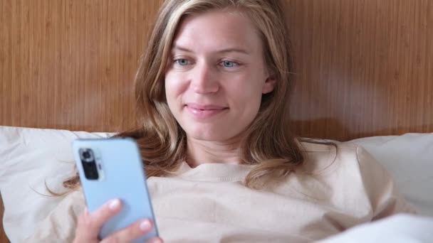 Ung Kvinna Som Använder Smartphone Hotellsäng Efter Att Vaknat — Stockvideo
