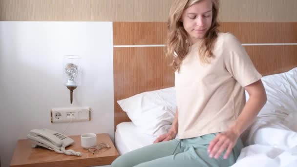ホテルの部屋で朝起きて伸びている若い女性 — ストック動画