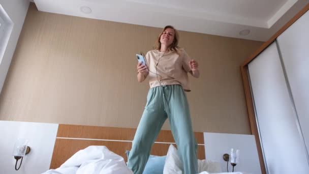 Junge Frau Tanzt Auf Dem Bett Hotelzimmer Und Genießt Ihren — Stockvideo