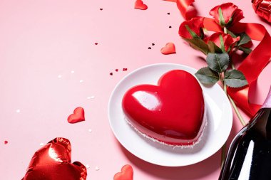 Sevgililer Günü. Kalp şeklinde jöleli sevgililer günü pastası ve pembe arka planda çiçekler, kopyalama alanı